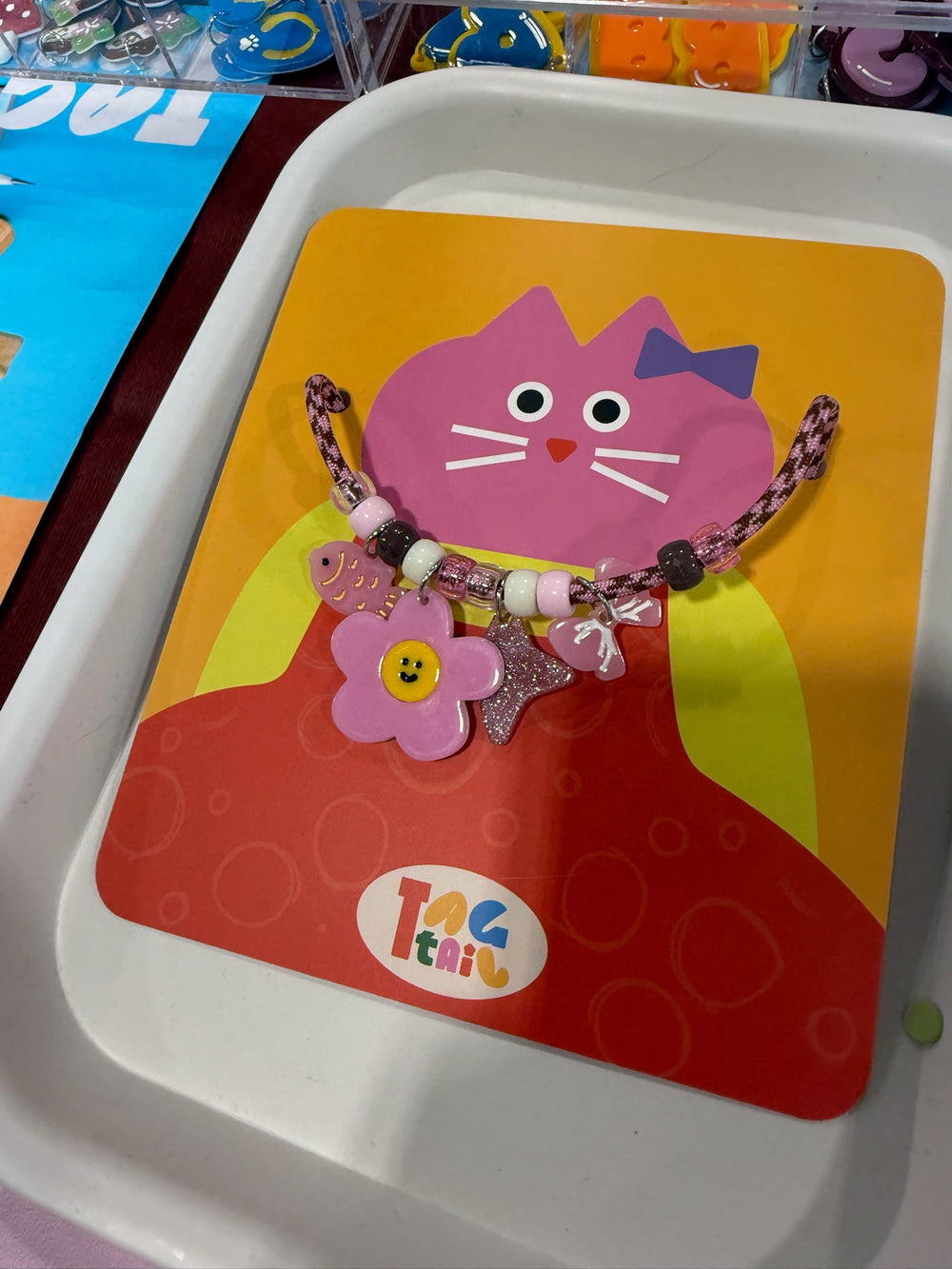 Pink Tagtail necklace with flower, bow, fish and star charms